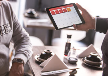 Jemand bedient eine Software auf einem Tablet.