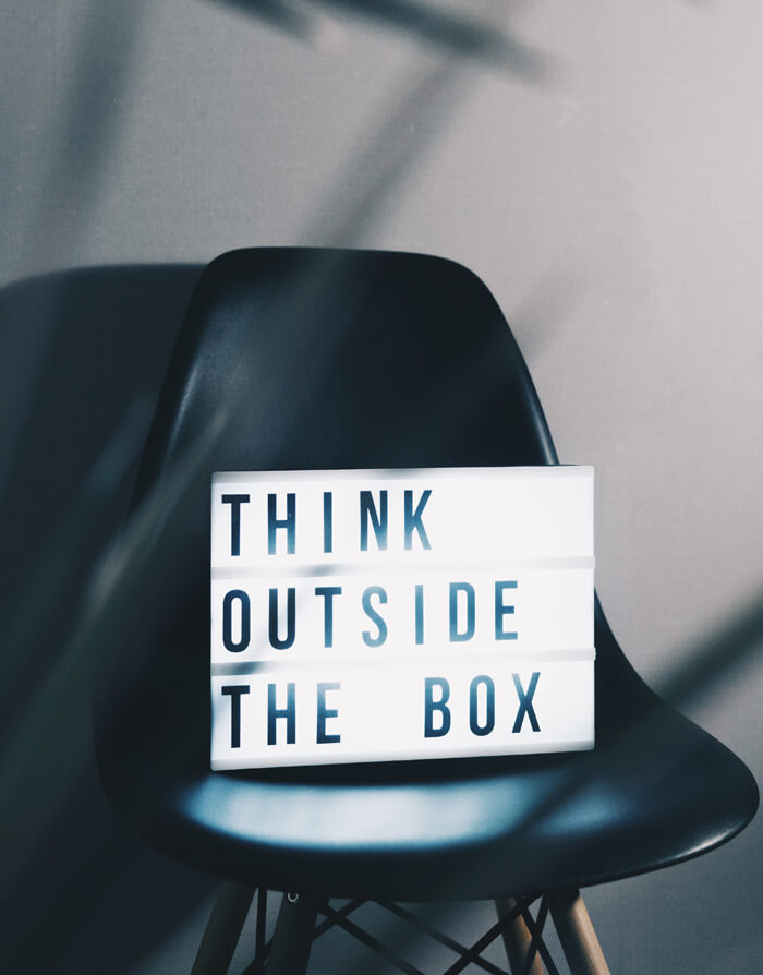 Ein Stul auf dem ein Schild steht, auf dem steht "Think outside the box"