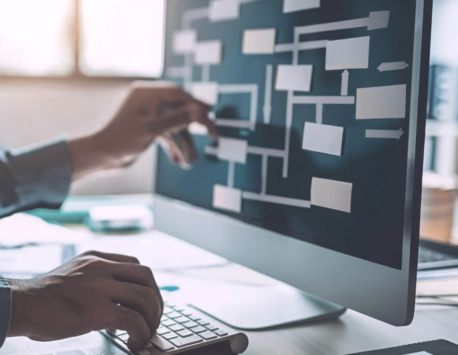 Person die einen Workflow mit Haftnotizen auf den Monitor klebt.