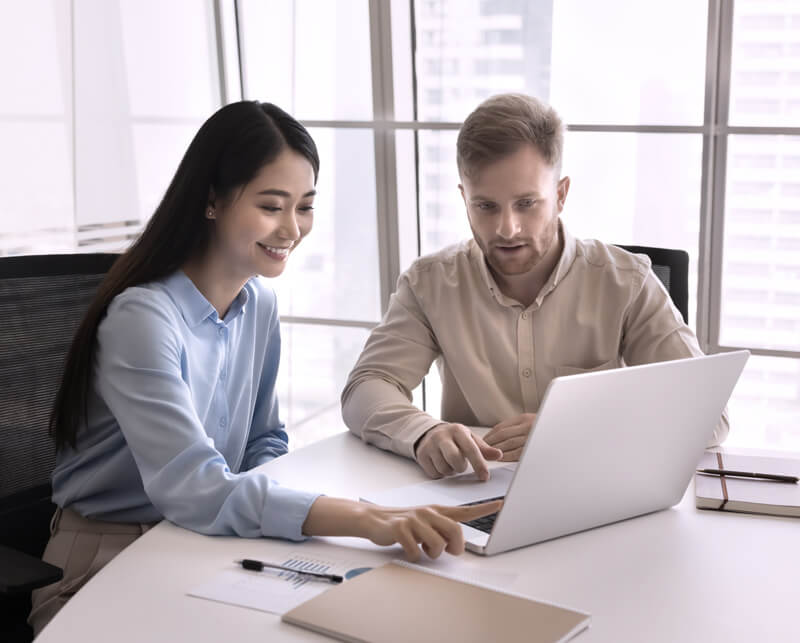 Zwei Menschen, die zusammen am Laptop arbeiten